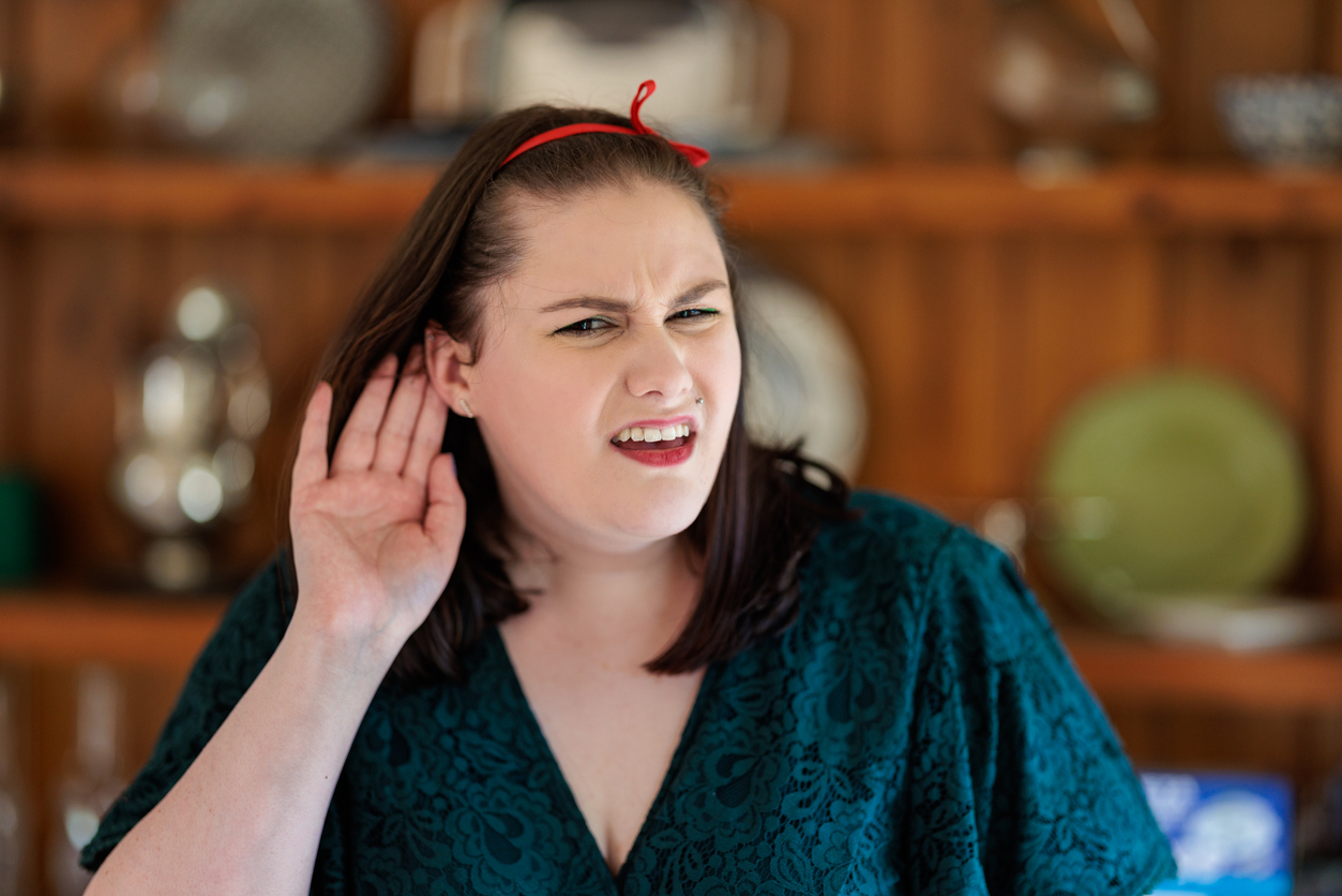 Woman in the beginning stages of hearing loss struggling to hear.
