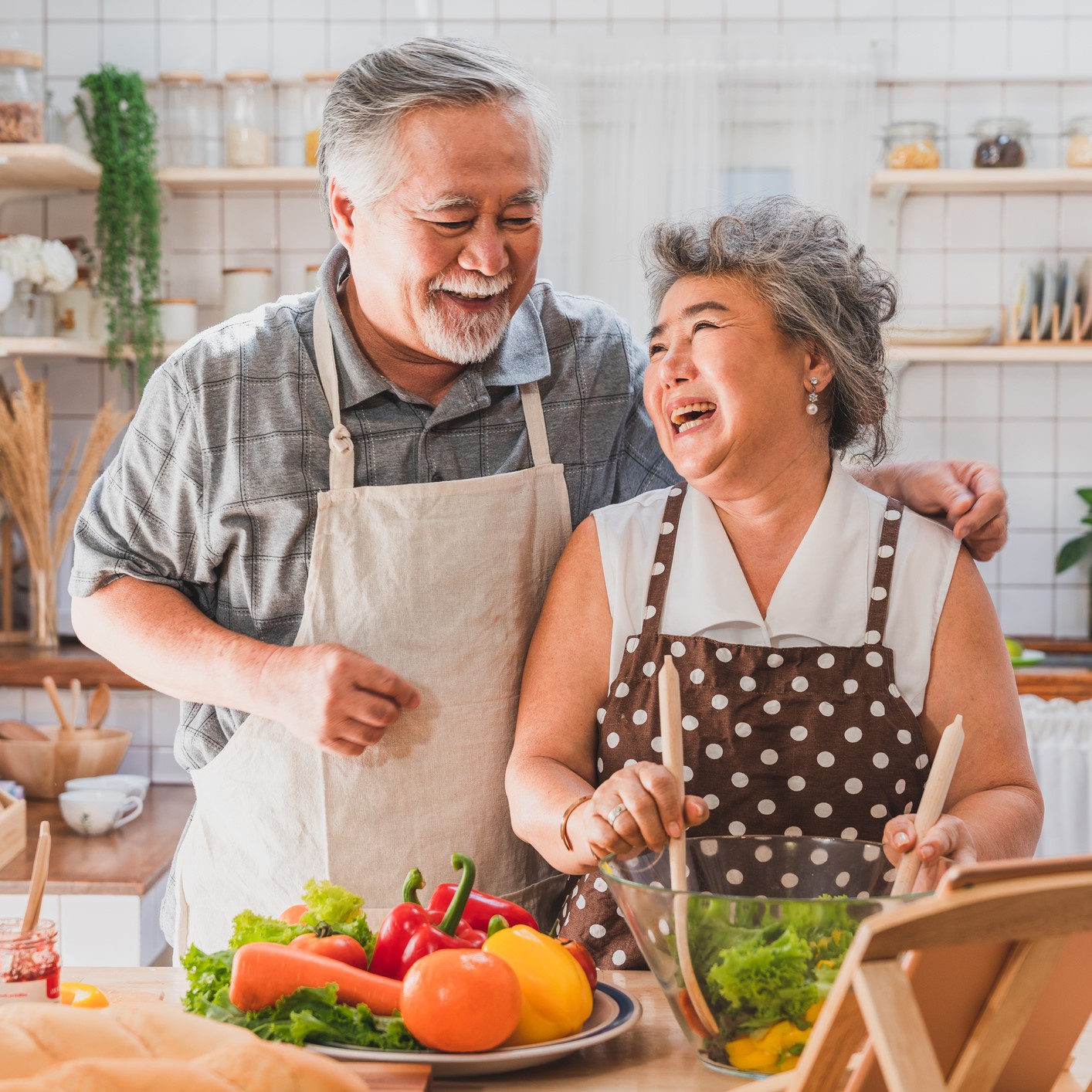 Happy older couple cooking in the kitchen.