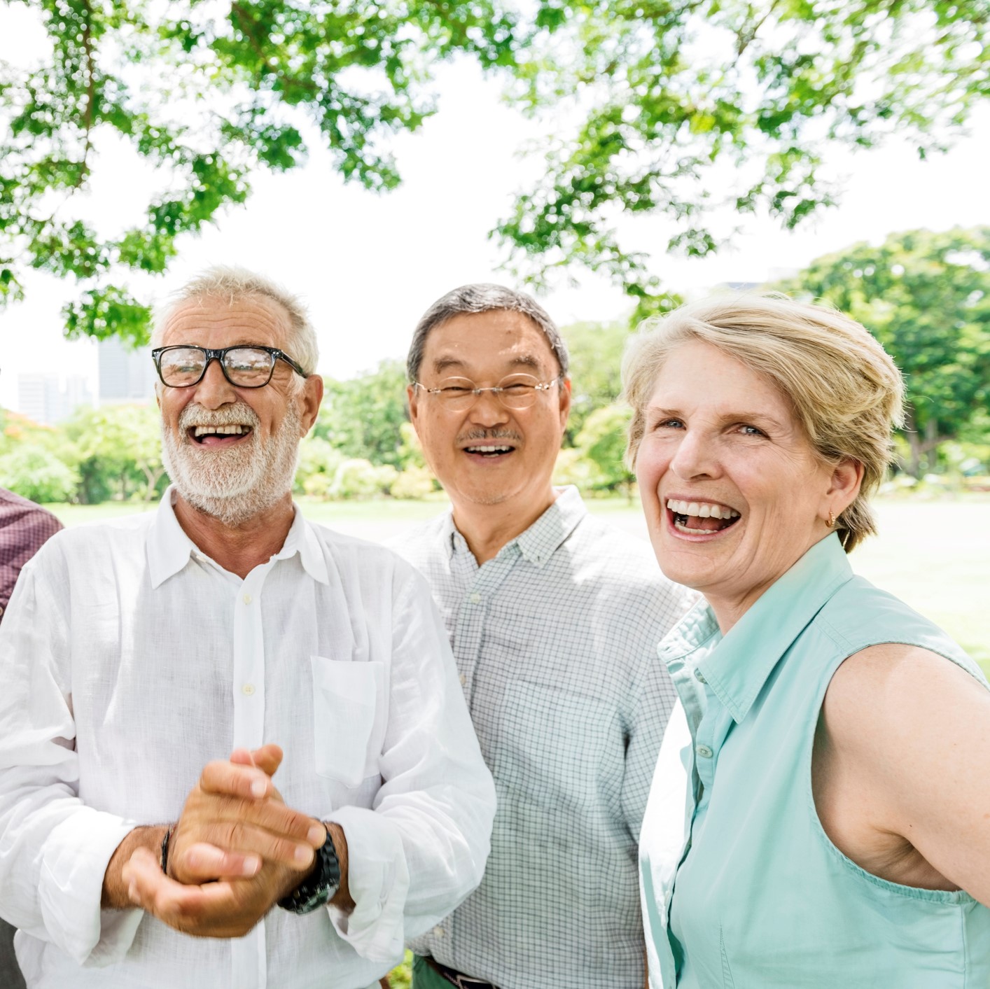 Group of friends laughing and smiling in a park.