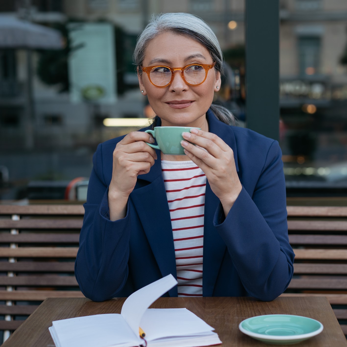 Smiling woman enjoying a coffee at an outdoor cafe