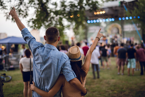 Couple cheering and enjoying an outdoor music festival