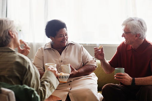 Group of old friends catching up over coffee and cookies.